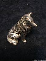 Angled front-left side of the sterling silver Collie dog figurine showing detailed fur texture and sitting pose.