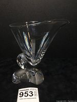 Front angle of clear crystal bowl with snail shell base on a black fabric background.