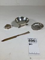 Overview of the 4 pieces: shell trinket box, footed bowl, shell plate, and knife with serrated blade.