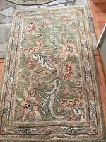 Rectangular 3 ft x 5 ft wool area rug with sage green background and multicolor floral pattern, showing full rug and border details.