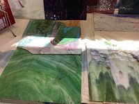 Four green and marbled white-striped glass panels on workbench
