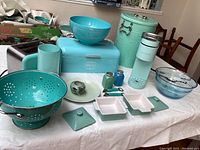 Overview of turquoise and sea foam kitchenware including toaster, bread box, bowls, strainer, trash can, Keurig, casseroles, and decorative pieces.