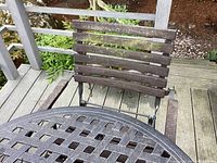 Close-up of weathered wooden slat back of patio chair showing wear and outdoor exposure