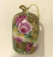 Full view of the antique porcelain bud vase showing hand-painted floral decorations and handle.