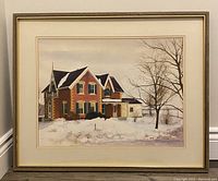 Framed watercolour painting showing a farmhouse in winter with snow, signed by the artist.
