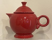 Front view of scarlet Fiesta Ware teapot with lid showing rounded body, spout, and circular handle
