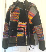 Front view of medium-sized wool coat with colorful patchwork pattern and zippered pocket.