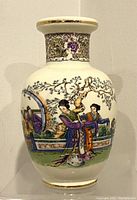 Front view of the porcelain vase showing hand-painted scene of women in traditional Chinese dress with a tree and architectural backdrop.