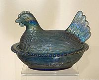 Front view of the blue carnival glass chicken/hen candy bowl on display.