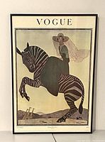 Full view of the framed vintage Vogue print featuring a woman on a zebra with giraffes in background.