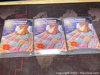 Three Canada Tiny Treasures uncirculated coin sets from 2001, 2002, and 2003 in colorful packaging with teddy bear design.