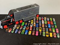 Black plastic carrying truck case with red wheels and transparent compartments for organizing die cast cars.