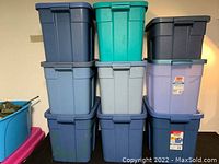 Front and side view of 9 stacked Rubbermaid containers in various colors including dark blue, teal, gray, light blue, and purple.