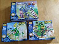 Three boxed LOZ dinosaur motor building block sets on wooden surface, showing front artwork and piece counts.