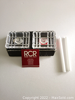 Pair of clear lead crystal taper candle holders, original gold labels visible, beside two unused white taper candles and red RCR card on white background.