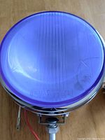 Top view of the blue round lens of the super mini spot lamp showing the Mattel brand name on lens.