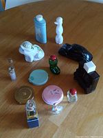 Front view of the lot showing a variety of vintage Avon perfume and cologne bottles along with makeup powder foundation compacts.