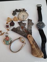Full overview of all items in the lot including watches, folding ruler, knife, pins, and cufflinks.