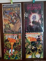 Four comics displayed together: three Teenage Mutant Ninja Turtles issues with Flaming Carrot cover art and one Clive Barker's Hellraiser comic with a dark cover.