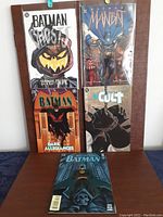 Photo of five DC Batman comics from the 1990s showing front covers including Batman Ghosts, Manbat, Dark Allegiances, The Cult, and another Batman issue.