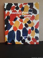 Front cover of the hardcover book showing colorful abstract brush strokes and the title 'Abstract Painting in Canada' by Roald Nasgaard.