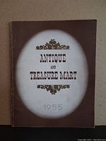 Brown softcover catalogue with white oval vignette on cover titled 'Antique and Treasure Mart 1955'