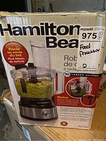 Box front showing Hamilton Beach brand, model number 975C, and photo of the food processor filled with chopped vegetables