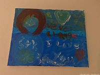 Front view of the hand painted artwork showing text and decorative elements on a blue background.