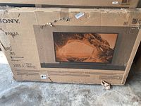 Original packaging box for Sony Bravia 55 inch X85J TV, showing model info and damage on box.
