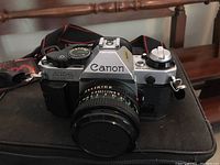 Close-up front view of camera body mounted with lens on top of bag