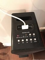 Top view of iCraig speaker control panel and iPhone dock with white cable connected.