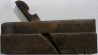 Side view of the antique wood block molding plane showing the angled groove and wedge securing the blade.