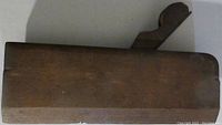 Top view of antique wooden molding plane showing solid wood block and top handle shape.