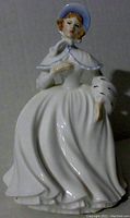 Front view of porcelain figurine Jessica by Royal Doulton, showing facial features, bonnet, cape, and flowing gown.