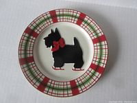 Plate showing black Scotty dog with red bow and shoes, plaid rim red, green, white