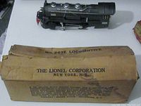 Image of original Lionel Corporation box for the No. 263E Locomotive with visible wear and creases, water stains, and printed labeling on the top and side.