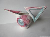 Front and side view of the ceramic pitcher showing triangular handle and colorful abstract design