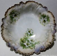 Top view photo of R.S. Prussia center bowl showing lily motif and gold trim around scalloped edge with some use wear.