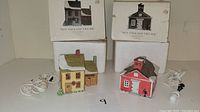 Two boxed and unboxed Dept 56 New England Village ceramic buildings with attached white electric lights