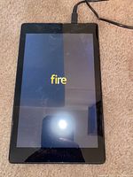 Amazon Fire HD 8 tablet powered on showing 'fire' logo on screen.