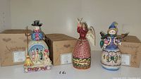 Front view of the three figurines and boxes behind them
