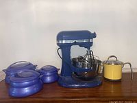 Overview showing blue stand mixer, three blue insulated containers and yellow pot