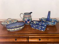 Whole set of one pitcher and four bowls arranged on a wooden surface showing overall condition and design details