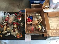 Full lot of assorted vintage-inspired Christmas ornaments and figurines on black table surface.
