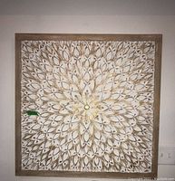 Full view of carved wooden wall art with floral and leaf pattern, painted white with gold accents