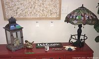 Photo of entire group showing lamp, lantern with faux acorns, two gold birds, welcome and hello signs, small pot and plant, and framed leaf art