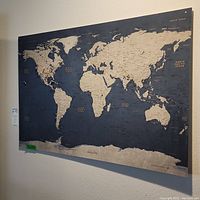 Large world map on a wall with location pins visible.