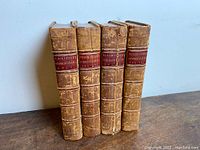 Front spines of four leather-bound volumes showing spine labels and wear