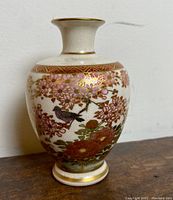 Front view of vase showing crackle glaze and gilt cherry blossom and bird decoration