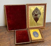 Two antique tin type photos each in original leather presentation cases with red velvet lining, decorative gold borders, and hinged lids.